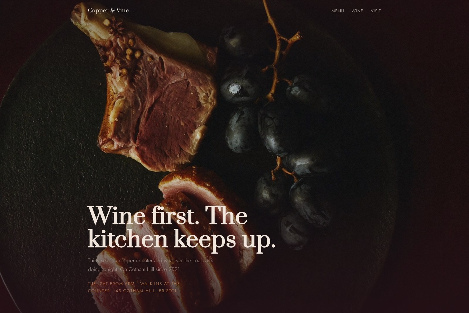 La page d'un bar à vin : un plat de canard à la bougie en pleine page dans la pénombre, le titre serif mordant le bas de l'image